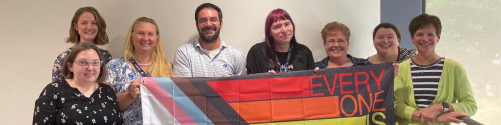 Incompass staff with a LGBTQ+ flag