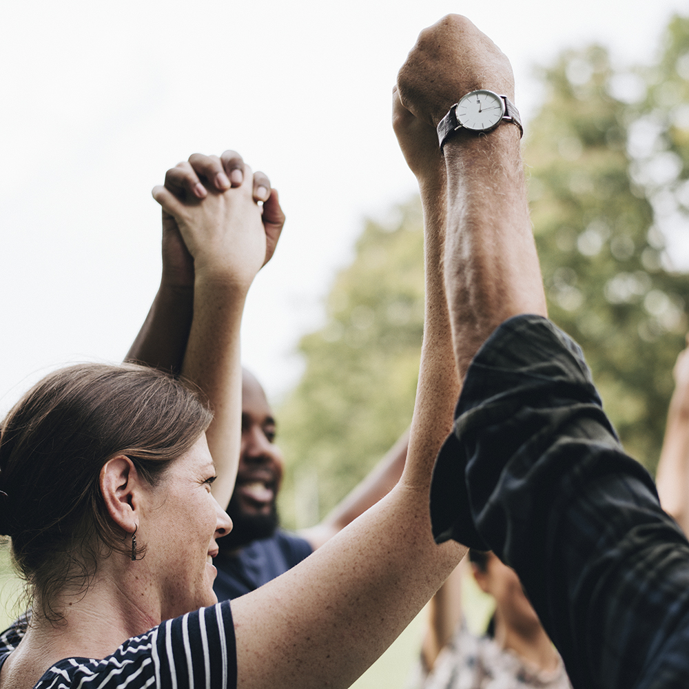 group smiling and raising hands