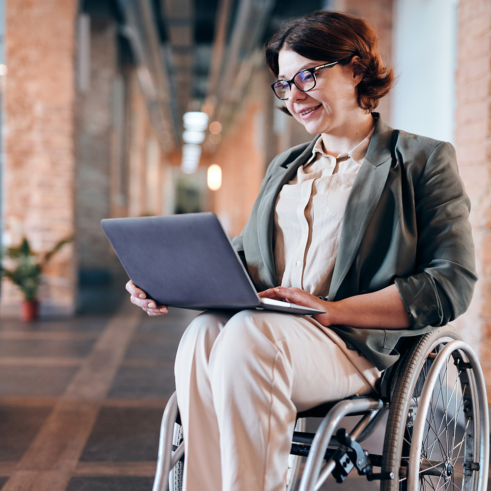 woman smiling with laptop in wheelchair
