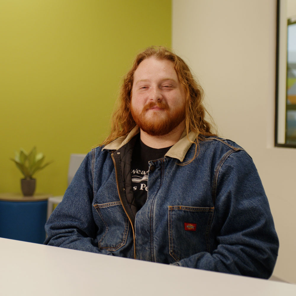 picture of a man with long red hair sitting in a jean jacket